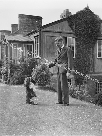 MAN WITH STANDING DOG